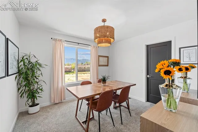 a dining room with furniture potted plants and wooden floor
