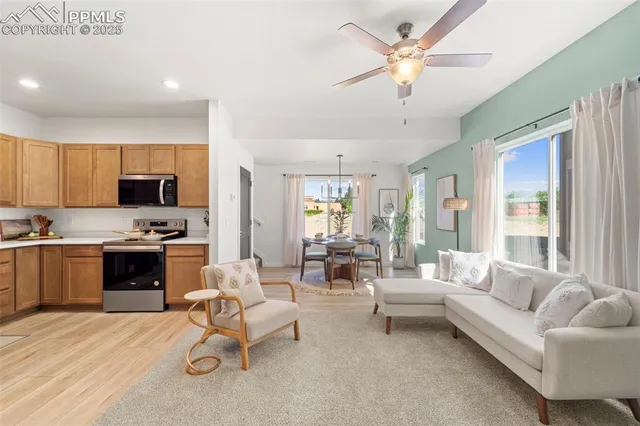 a living room with furniture white walls and kitchen view