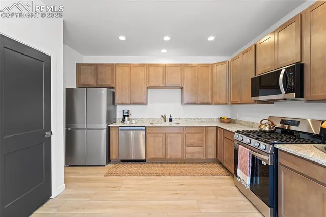 a kitchen with a sink a microwave a refrigerator and cabinets