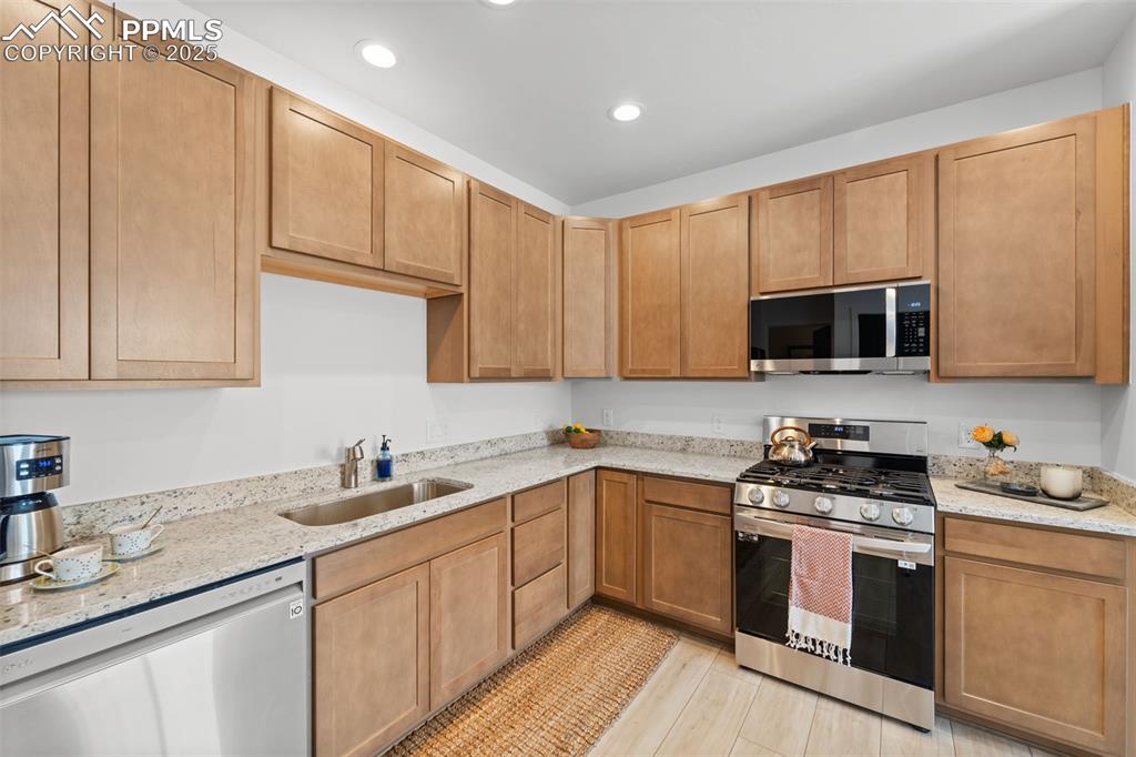 1920 Erin Loop Colorado Springs, CO 80918 - Photo 8 of 26 a kitchen with stainless steel appliances granite countertop white cabinets sink and stove top oven