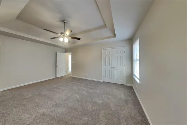 an empty room with a ceiling fan and a window