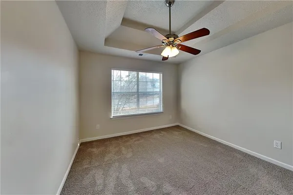 an empty room with windows and fan