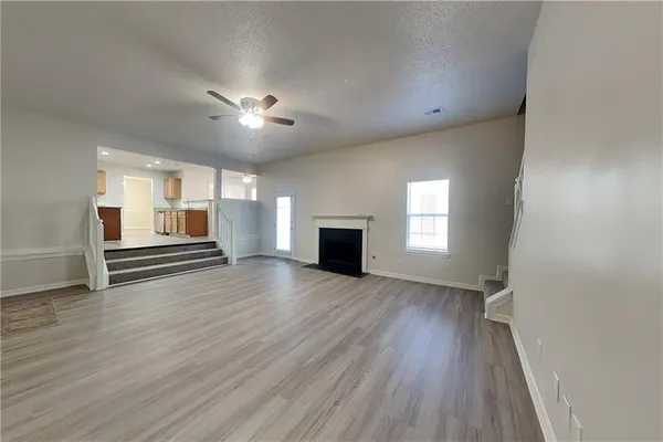 a view of empty room with a fireplace and wooden floor