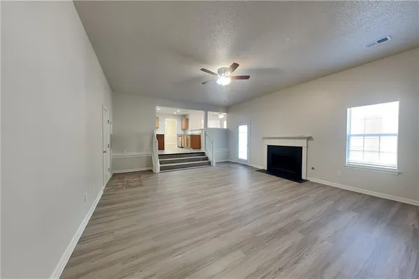a view of empty room with wooden floor and fireplace