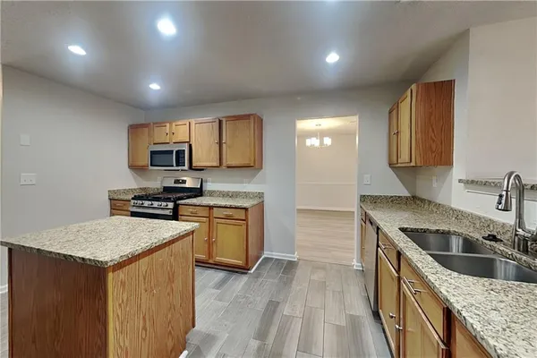 a kitchen with a sink stove top oven and refrigerator
