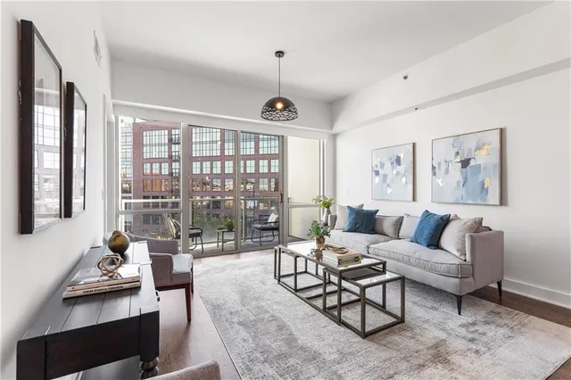 a living room with furniture large window and a table