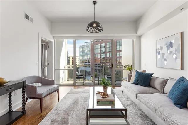 a living room with furniture a flat screen tv and a large window