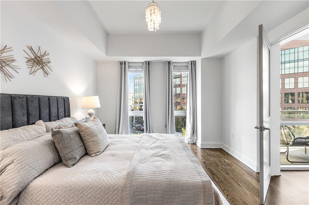 1100 Howell Mill Road Northwest, Unit 404 Atlanta, GA 30318 - Photo 15 of 45 a bedroom with a large bed and a chandelier