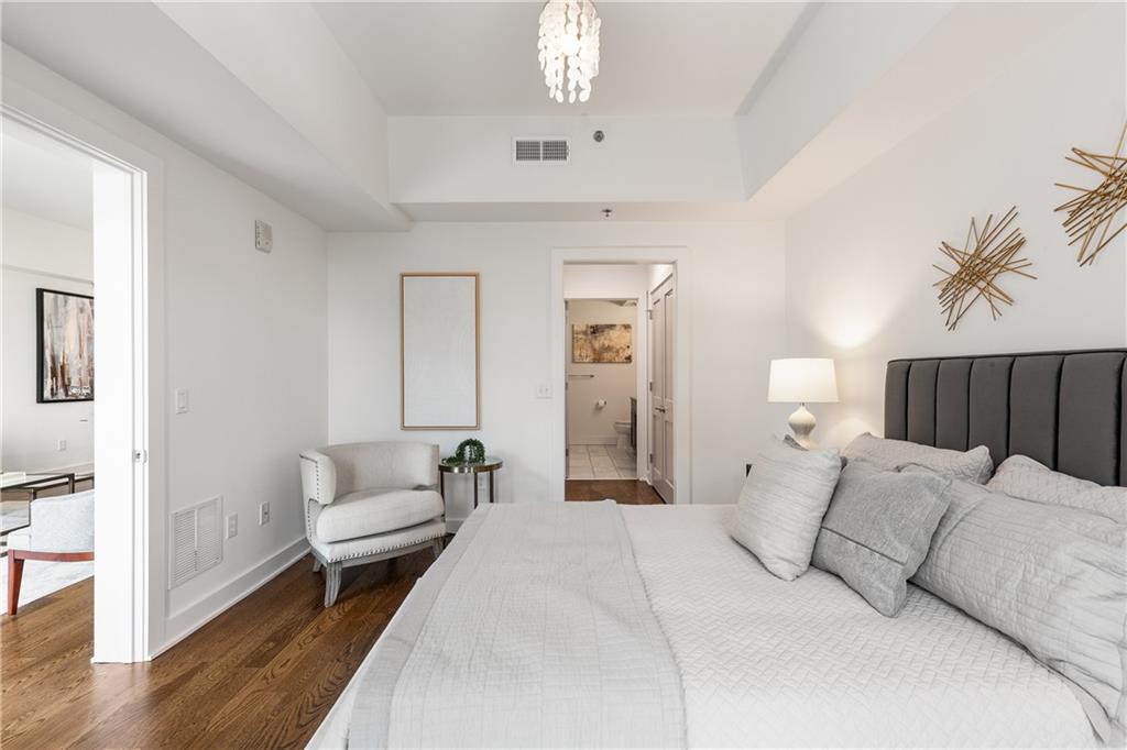 1100 Howell Mill Road Northwest, Unit 404 Atlanta, GA 30318 - Photo 18 of 45 a spacious bedroom with a bed a couch and chandelier