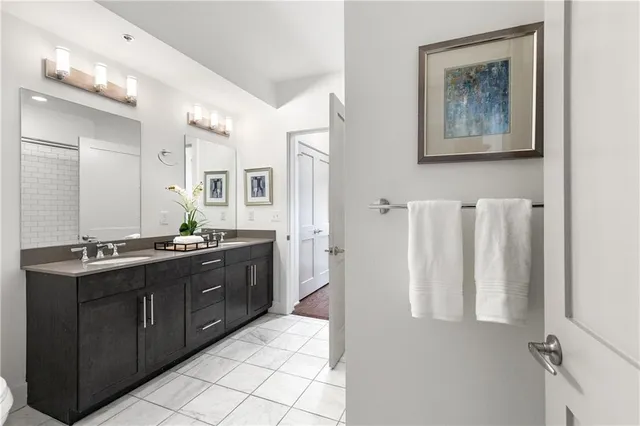 a spacious bathroom with a double vanity sink a mirror and a shower