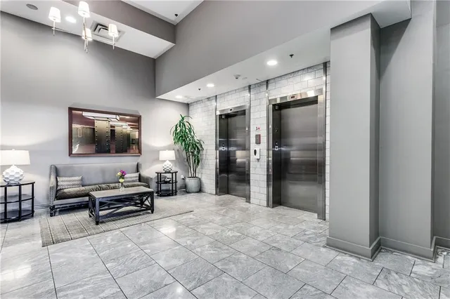 a living room with furniture a large window and a potted plant