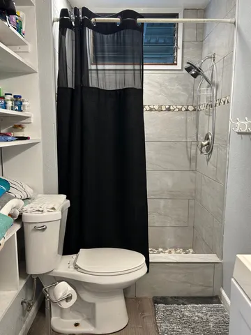 a bathroom with a toilet and a shower
