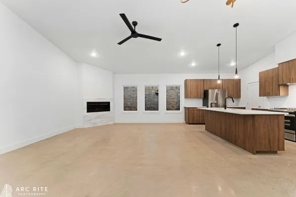 a large kitchen with kitchen island a sink stainless steel appliances and a chandelier
