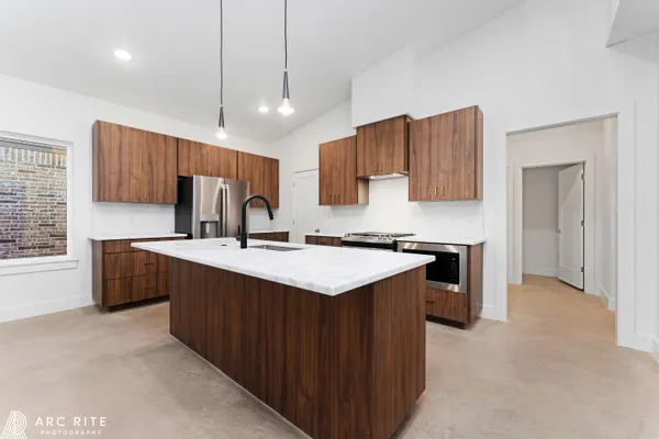 a kitchen with stainless steel appliances granite countertop a sink stove and refrigerator