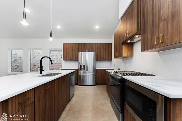 a kitchen with stainless steel appliances granite countertop a sink stove and refrigerator