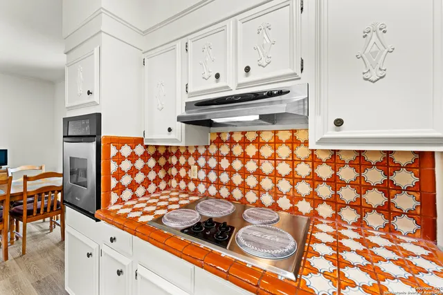 a kitchen with stainless steel appliances a stove a sink and cabinets