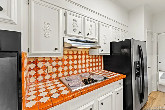 a kitchen with stainless steel appliances granite countertop a refrigerator and a stove