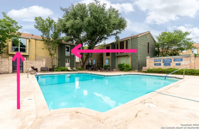 a view of swimming pool with a lawn chairs under an umbrella