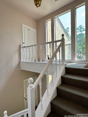 a view of staircase with white walls and a window