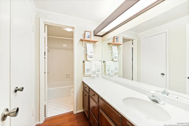 a spacious bathroom with a shower sink and mirror