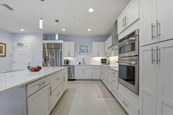 a kitchen with stainless steel appliances a refrigerator sink and cabinets