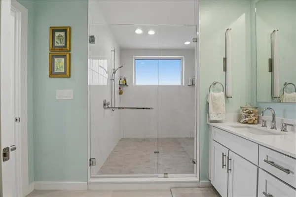 a bathroom with a shower sink and mirror