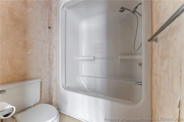 a white toilet sitting next to a bath tub