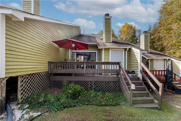 a view of a house with wooden deck and a yard