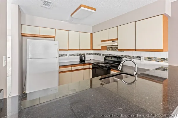 a kitchen with stainless steel appliances a refrigerator sink and cabinets