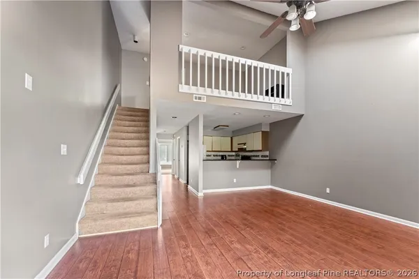 a view of a hallway with wooden floor and staircase