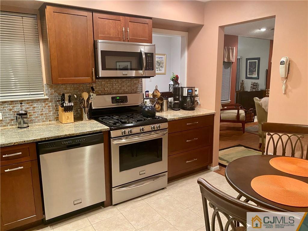 2 Park Gate Drive Edison, NJ 08820 - Photo 6 of 13 a kitchen with stainless steel appliances a stove a microwave a sink and cabinets