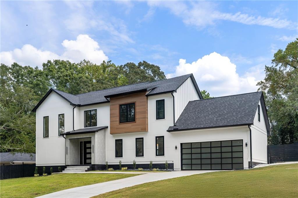 a view of a white house next to a yard with big trees