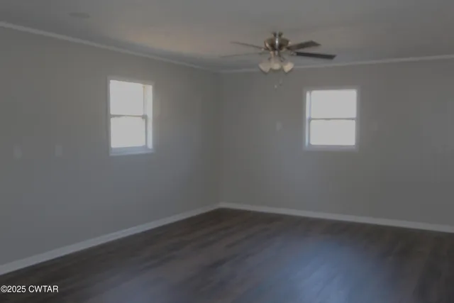 an empty room with a window and a fan