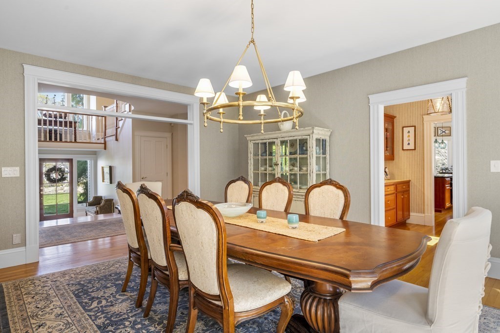 25 Foster Street Marblehead, MA 01945 - Photo 11 of 42 a dining room with wooden floor a chandelier a wooden table and chairs