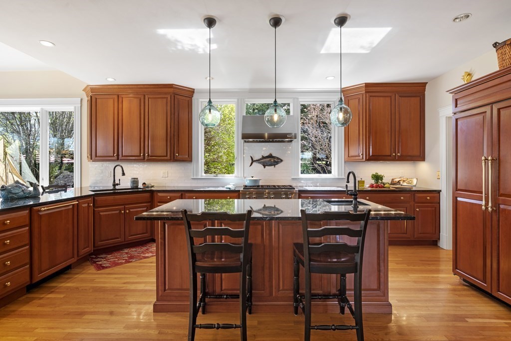 25 Foster Street Marblehead, MA 01945 - Photo 12 of 42 a kitchen with stainless steel appliances granite countertop wooden floors and wooden cabinets
