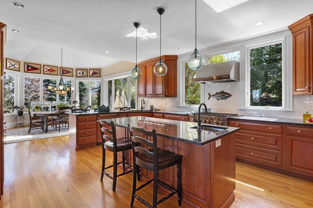 25 Foster Street Marblehead, MA 01945 - Photo 13 of 42 a kitchen with stainless steel appliances granite countertop a stove a sink a island with a dining table and chairs
