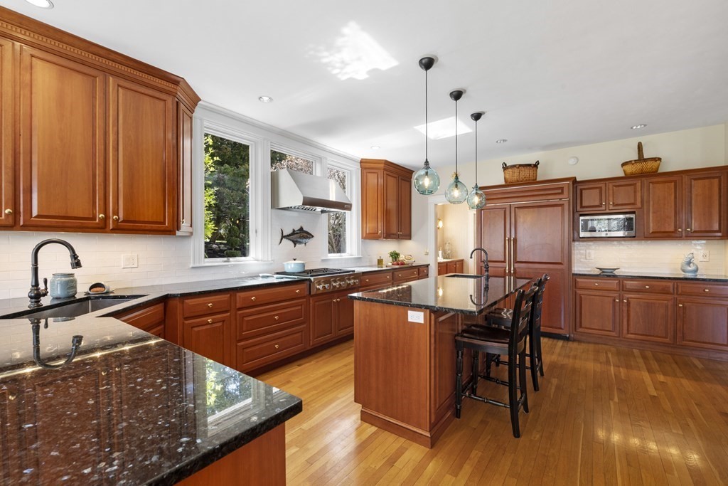 25 Foster Street Marblehead, MA 01945 - Photo 15 of 42 a kitchen with stainless steel appliances granite countertop wooden floors and a sink