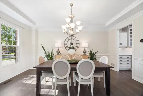 a table with chairs a chandelier and a dining table