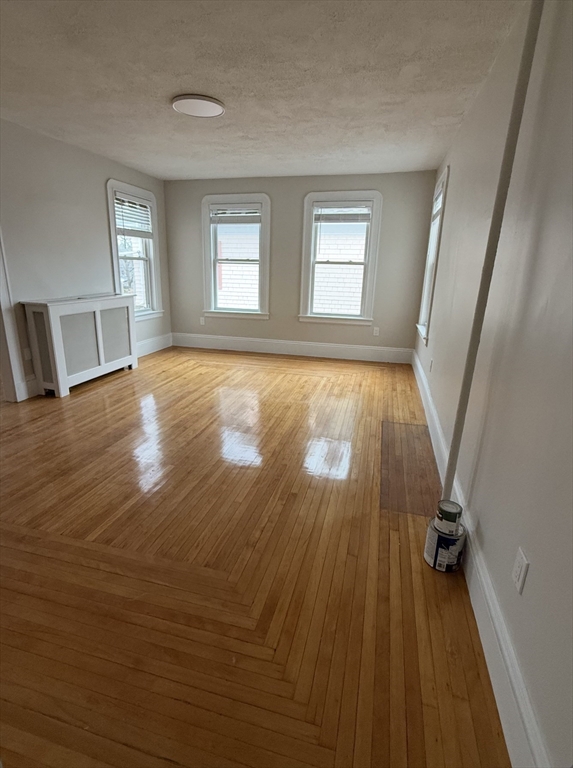 98 Paradise Road, Unit 1 Swampscott, MA 01907 - Photo 2 of 10 a view of empty room with wooden floor and fan