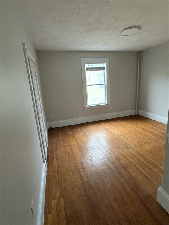 98 Paradise Road, Unit 1 Swampscott, MA 01907 - Photo 7 of 10 an empty room with wooden floor and windows