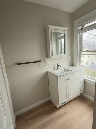 a bathroom with a granite countertop sink and a mirror