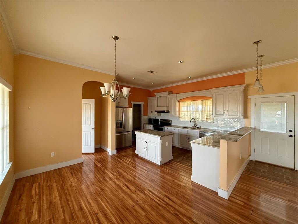 487 County Road 2622 Decatur, TX 76234 - Photo 4 of 20 a kitchen with sink a refrigerator and wooden floor