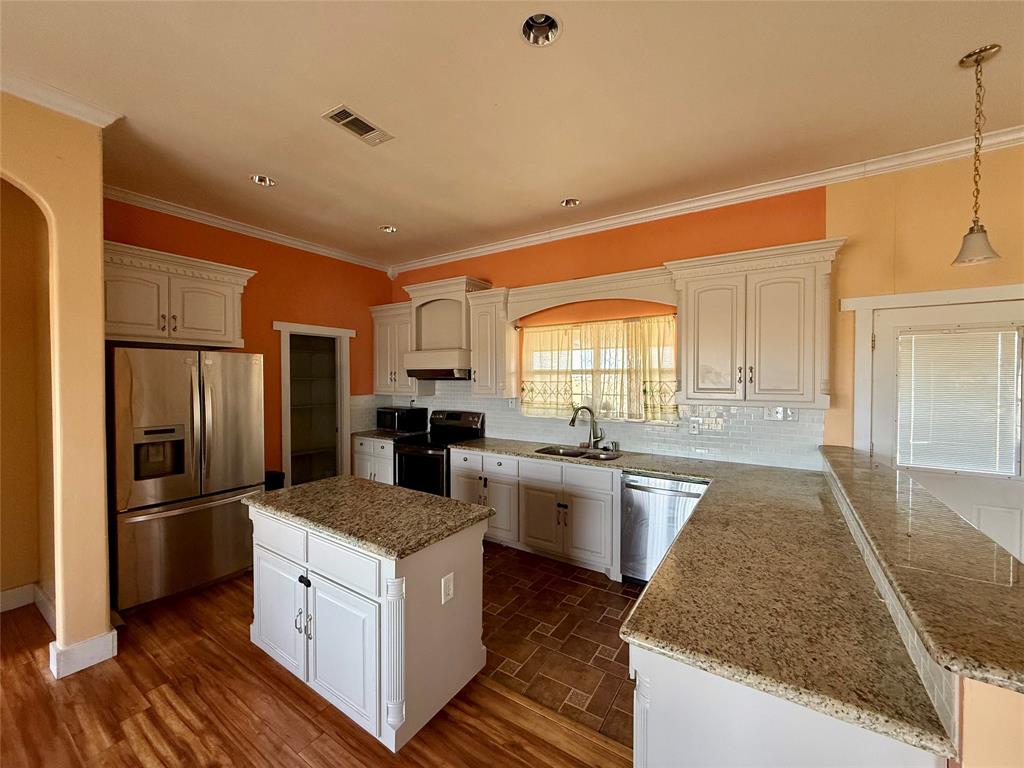 487 County Road 2622 Decatur, TX 76234 - Photo 5 of 20 a kitchen with sink refrigerator and stove