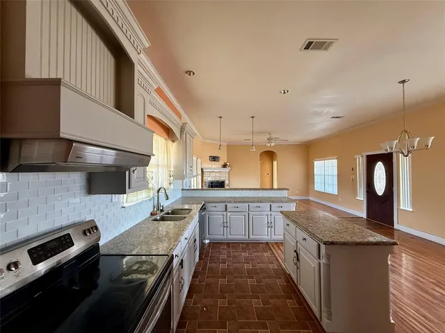 a large kitchen with stainless steel appliances granite countertop a stove and a sink
