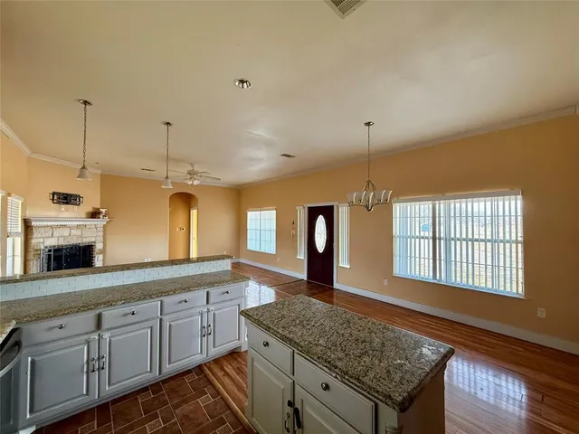 a kitchen with stainless steel appliances granite countertop a sink a stove and a wooden cabinets