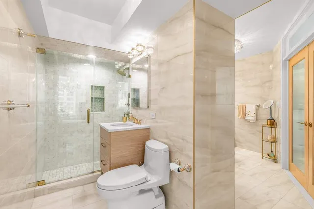 a bathroom with a bathtub shower sink mirror vanity and toilet