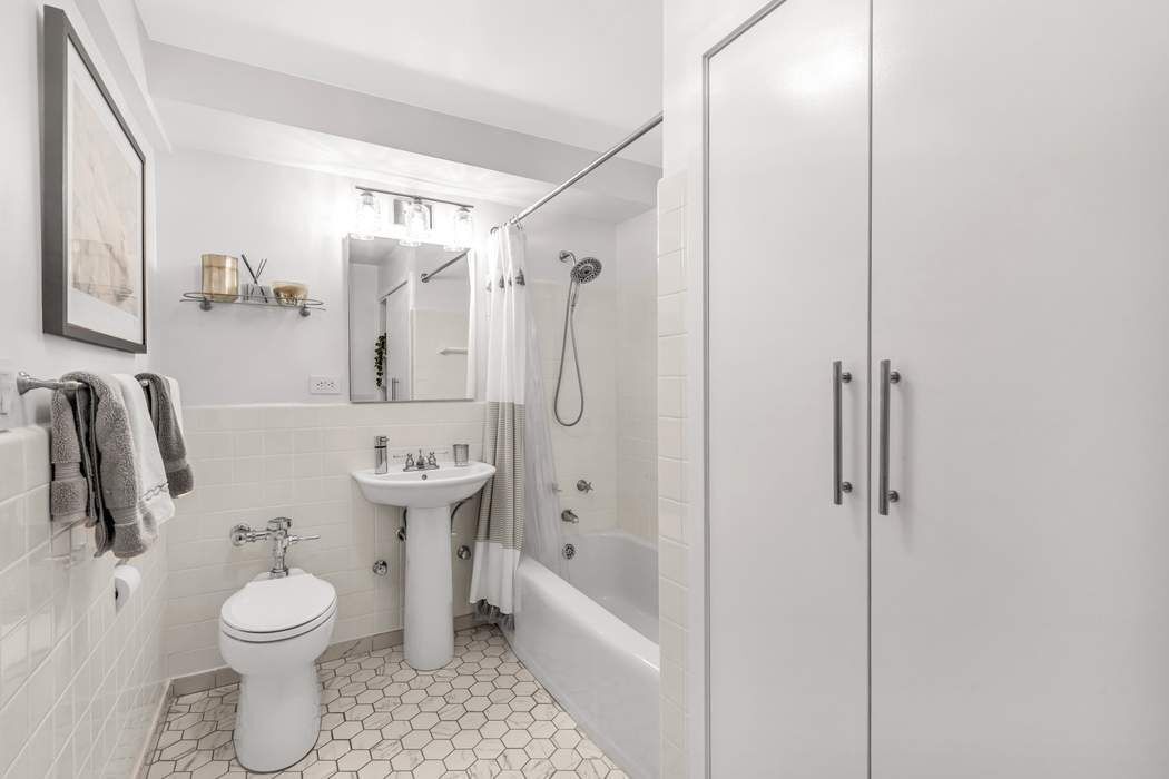 249 East 48th Street, Unit 10B Manhattan, NY 10017 - Photo 14 of 18 a bathroom with a toilet sink and shower