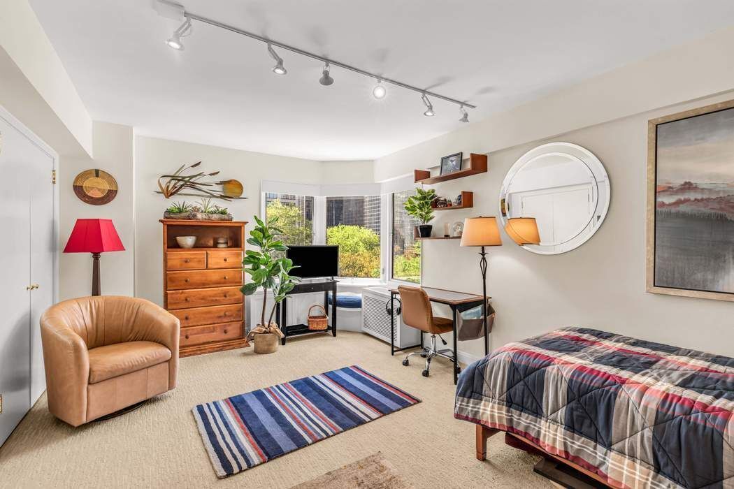 249 East 48th Street, Unit 10B Manhattan, NY 10017 - Photo 15 of 18 a living room with furniture and a painting on the wall