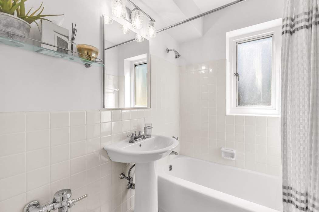 249 East 48th Street, Unit 10B Manhattan, NY 10017 - Photo 16 of 18 a bathroom with a sink bathtub and a shower