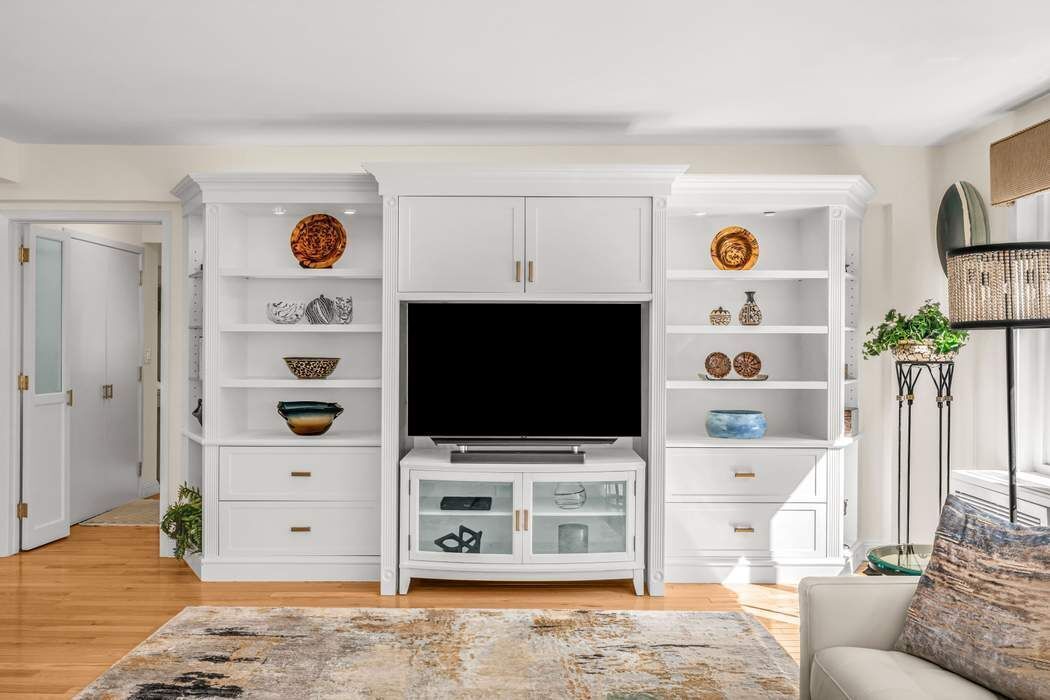 249 East 48th Street, Unit 10B Manhattan, NY 10017 - Photo 3 of 18 a living room with furniture and a flat screen tv